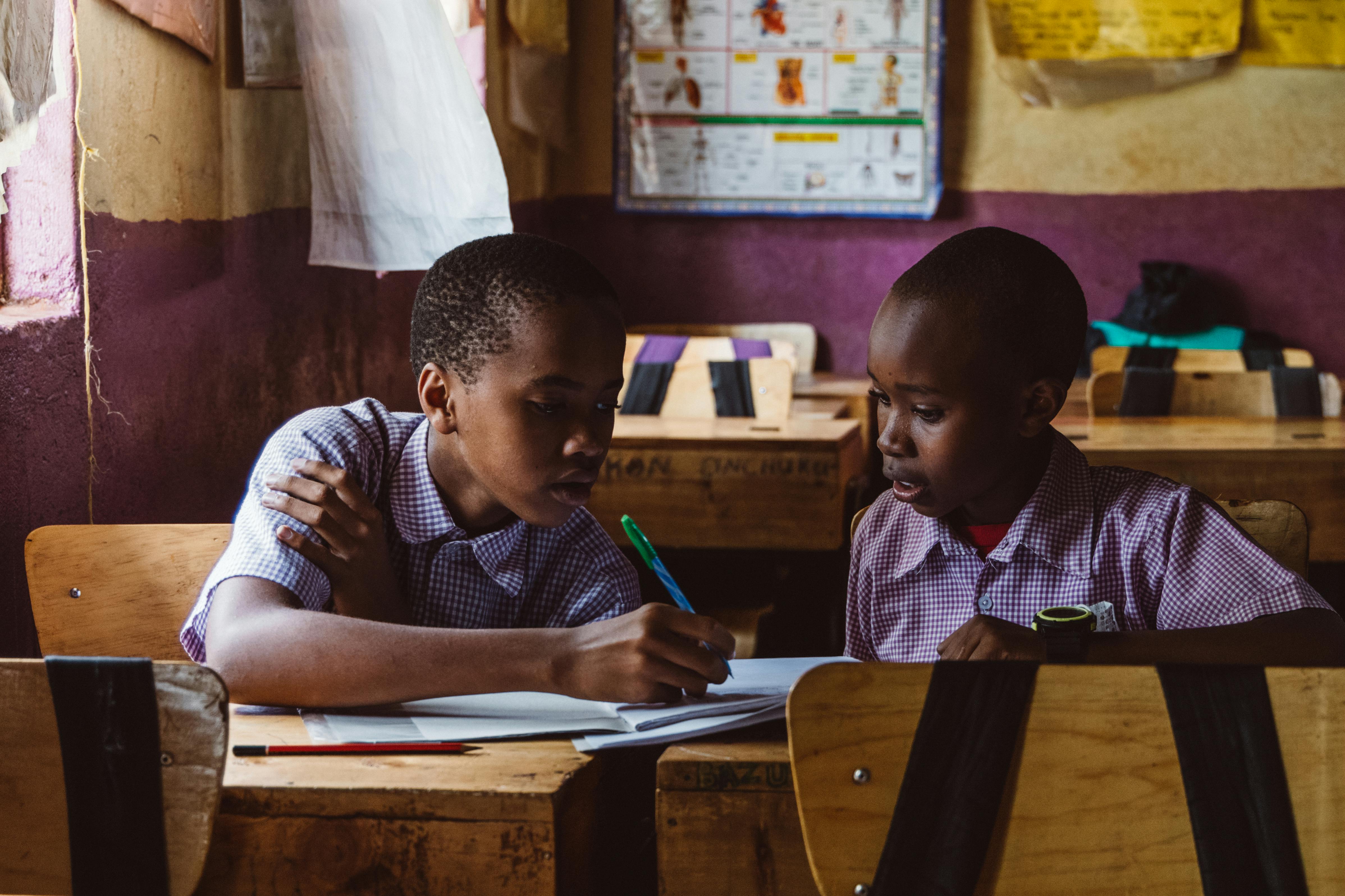 African students collaborating on laptops in a modern classroom