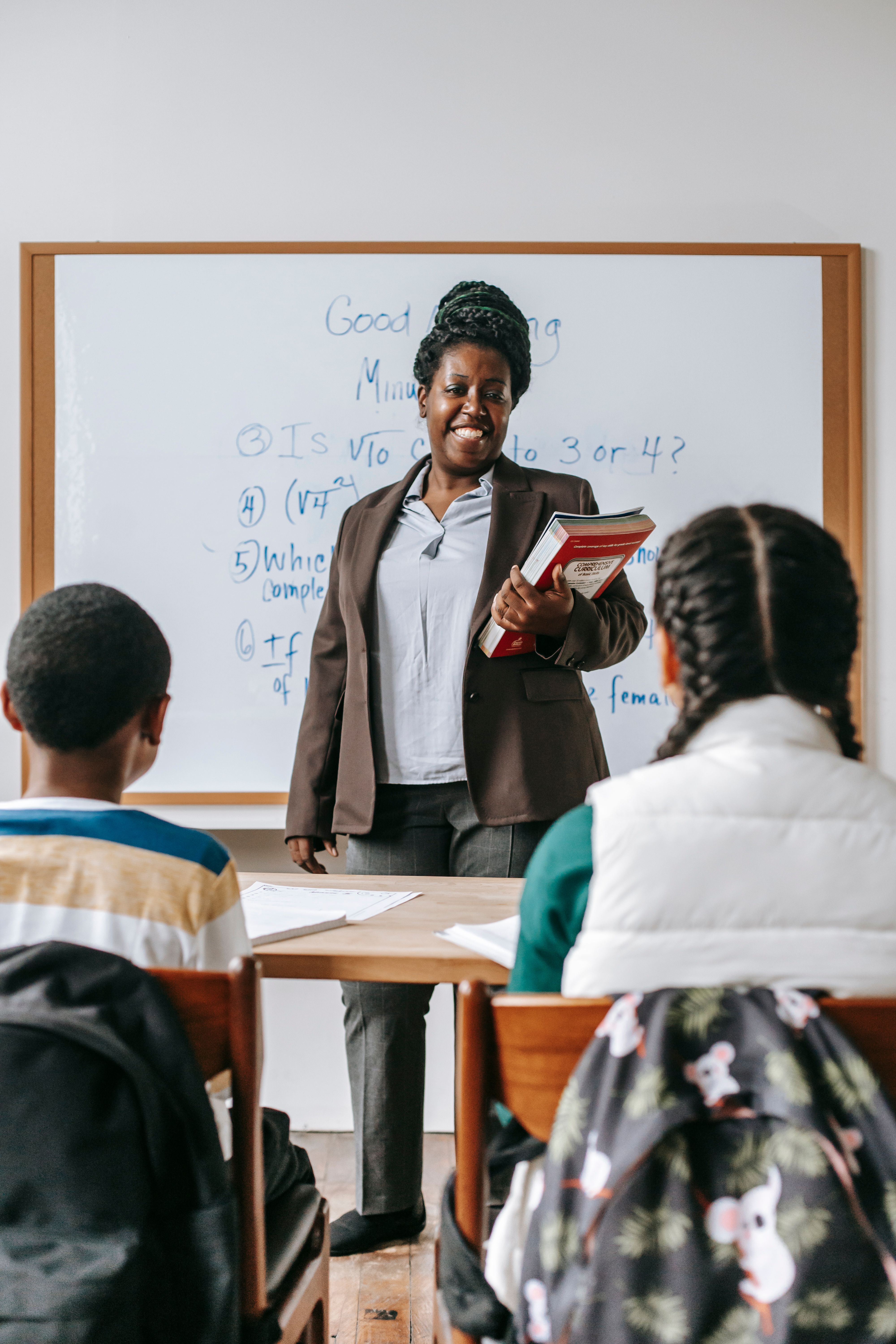 Cheerful African teacher interacting with students in a classroom